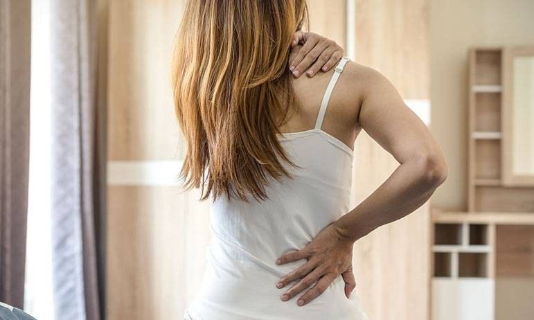 ragazza che si tocca la schiena e la scapola