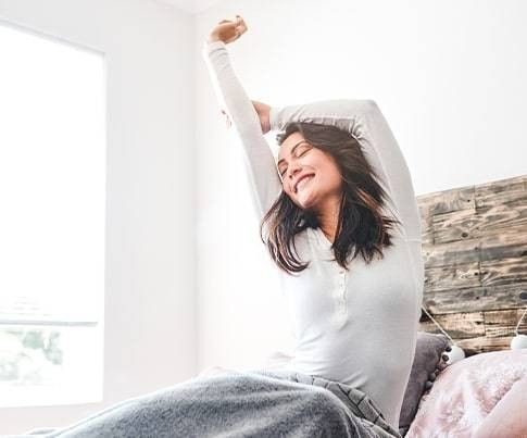 donna che allunga i muscoli della schiena al risveglio