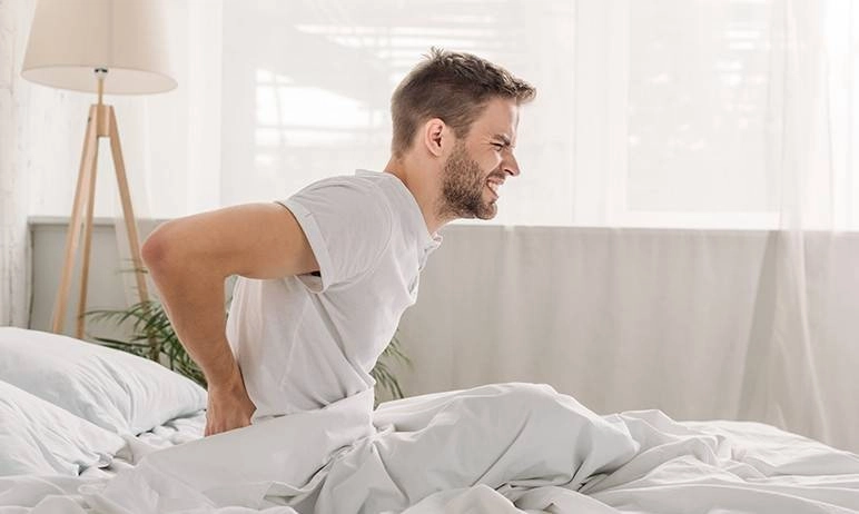 ragazzo con schiena dolorante a letto