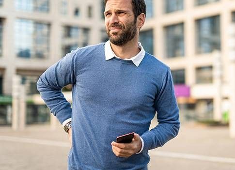 ragazzo che si tocca la schiena dolorante