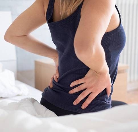 ragazza di spalle che si tocca la parte inferiore della schiena
