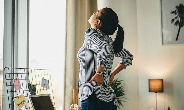 ragazza in piedi che si tocca la schiena